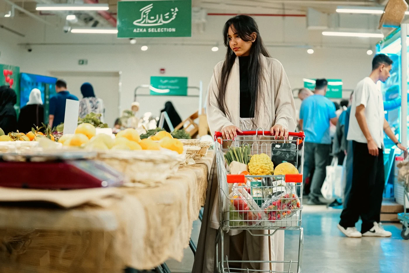 سوق المزارعين بحي جميل — زائرة تتسوق منتجات عضوية